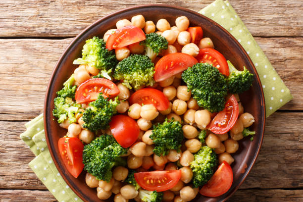 istock Vegetable salad from broccoli, chickpeas and fresh tomatoes with olive oil close-up. Horizontal top view 1156048639