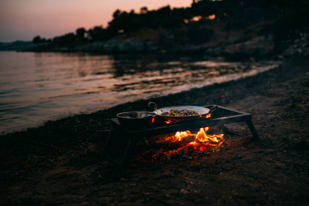 istock Food Cooked on Campfire Burning on the Beach 1156050110