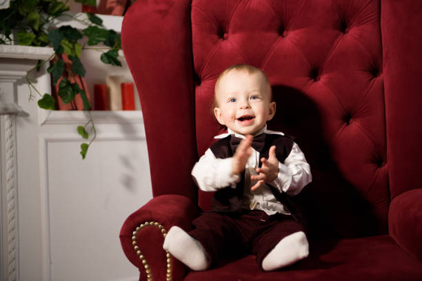 One-year-old cheerful baby boy plays at home. Portrait of a cute playful baby.