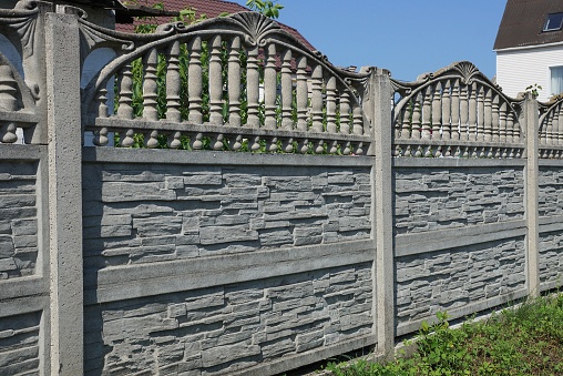 long gray stone fence in green grass outside