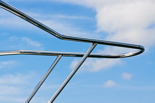 Closeup motor yacht railing against blue sky with clouds, full frame horizontal composition with copy space
