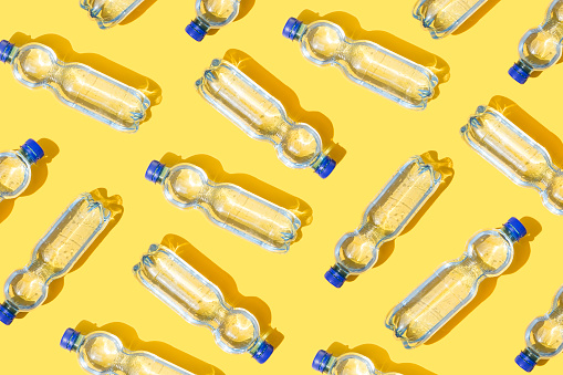 Mineral water bottles pattern on yellow background