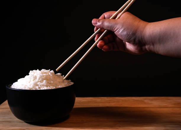 istock Rice in a bowl on a black background in the studio 1156062402