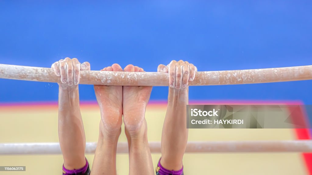 Hands and feet young girl gymnast exercises on bar Gymnastics Stock Photo