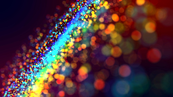 a cloud of multicolored particles in the air like sparkles on a dark background with a small depth of field. beautiful bokeh light effects with colored particles. background for holiday presentations
