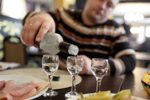 homme versant la vodka dans le pub - eastern european caucasian one person alcoholism photos et images de collection