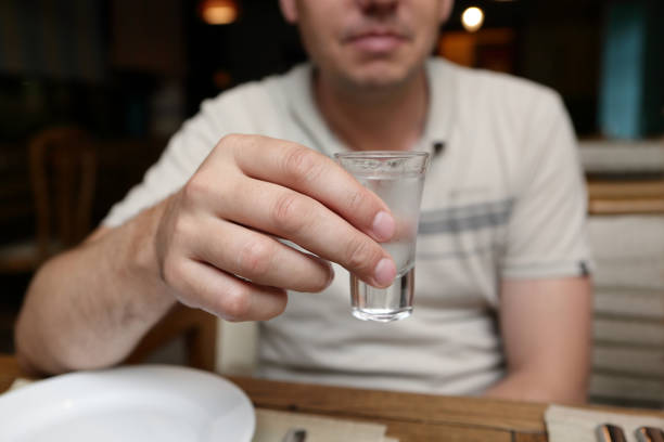 homem com vidro da vodca - copo pequeno para bebida alcoólica - fotografias e filmes do acervo