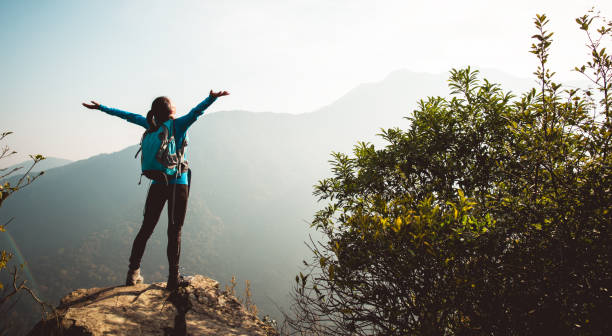 caminhante bem sucedido com os braços outstretched na parte superior da montanha do nascer do sol - sunrise asia china climbing - fotografias e filmes do acervo