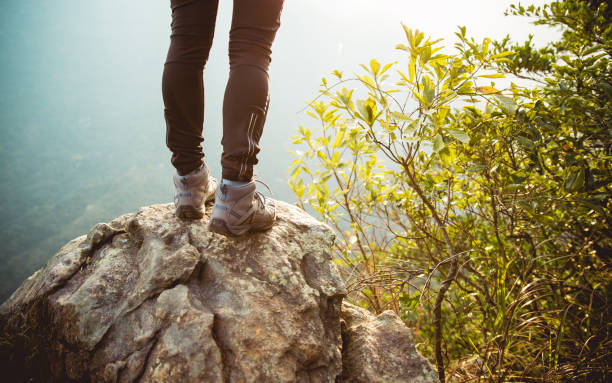istock Woman hiker legs on mountain peak rock cliff edge 1156068239