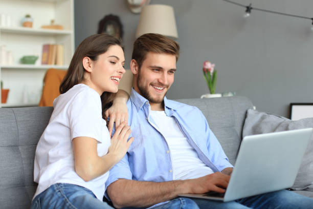 istock Young couple doing some online shopping at home, using a laptop on the sofa. 1156068768