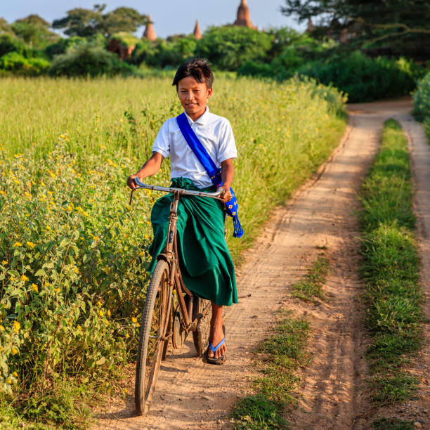 istock Burmese schoolboy riding a bicycle in Bagan, Myanmar 1156071282