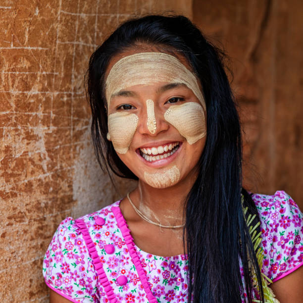 Young Burmese girl with thanaka face paint posing in the ancient temple of Bagan, Myanmar (Burma)