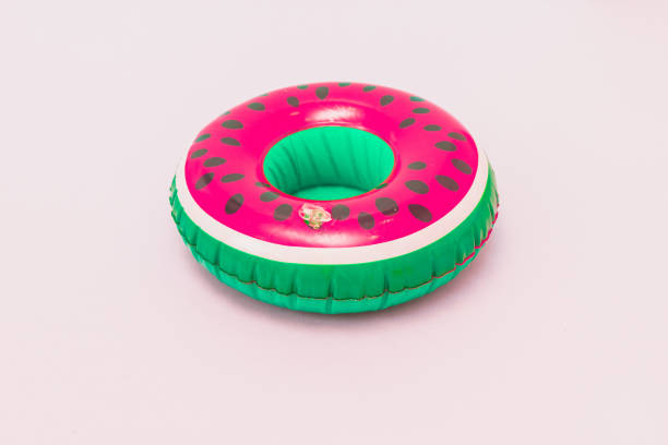 pool toy in shape of watermelon on pastel pink background. Soft colors Inflatable pool toy in shape of watermelon on pastel pink background. Soft colors inflatable ring photos stock pictures, royalty-free photos & images