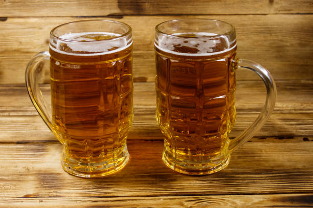 istock Two mugs of beer on a wooden table 1156073994