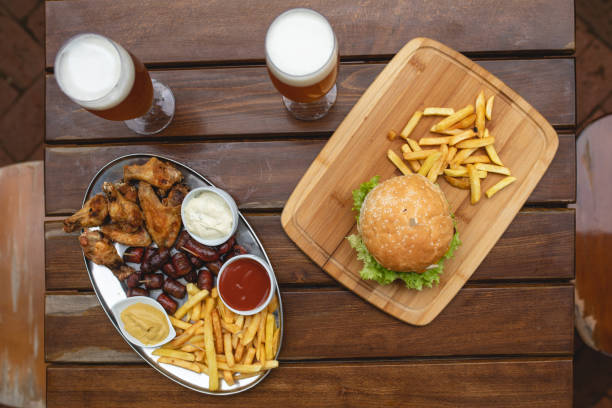 fast food, snacks and drink on table - beer hamburger american culture beef imagens e fotografias de stock