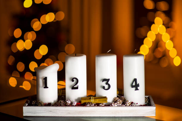 istock Advent candles in a row with decoration on a stand with christmas tree and a triangle candle on a background 1156079384