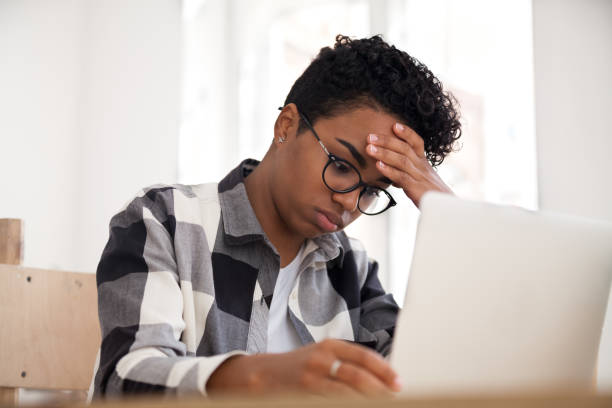 istock Upset american woman sitting working using laptop in office 1156082375