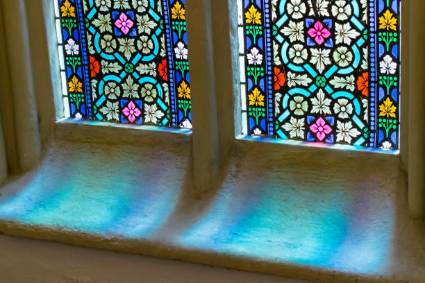 istock Light through colored glass in window in old church 1156083434