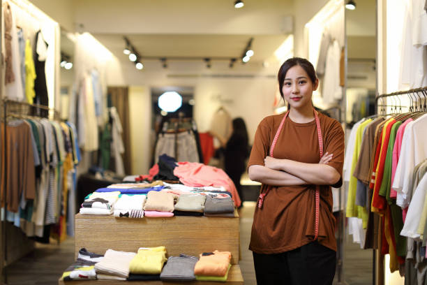 young woman business owner in a clothes shop, portrait - owner boutique store retail imagens e fotografias de stock