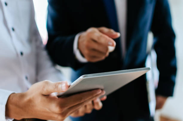 istock two young partner business man investor talking about financial statistics chart information in mobile tablet together in meeting room at office, finance, investment and digital technology concept 1156085138