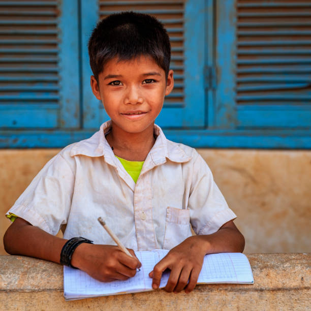 istock Cambodian schoolboy doing homework near Tonle Sap, Cambodia 1156087952