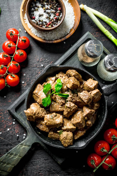 istock Fried liver with spices and cherry tomatoes on a cutting Board. 1156089380