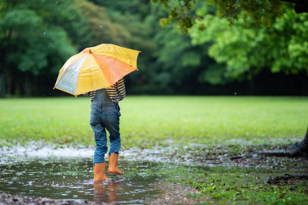 istock Girl walking with umbrella 1156089729