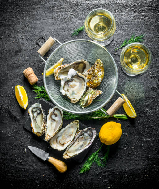 istock Raw oysters in a colander with white wine, lemon and dill. 1156090322