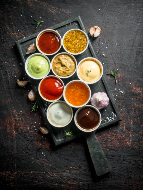 different types of sauces in bowls on a cutting board with garlic. - 7963 imagens e fotografias de stock