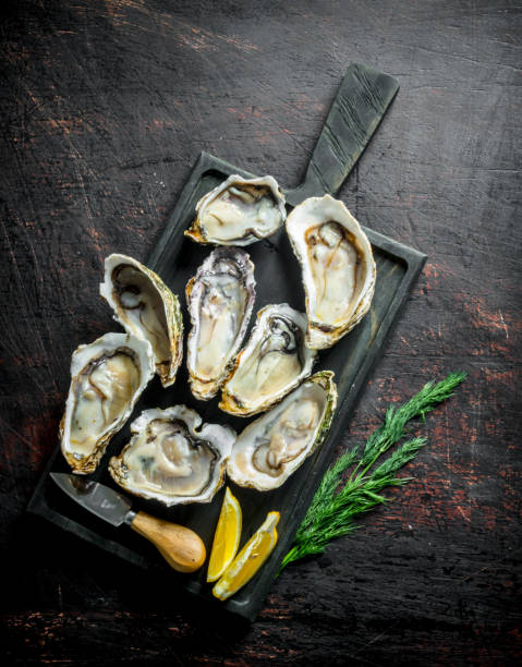 istock Fresh oysters on a cutting Board with dill and lemon. 1156091058