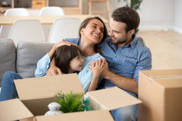 istock Smiling parents relax with daughter on home couch 1156092025