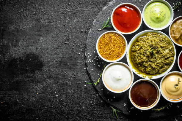 istock An assortment of different sauces in bowls on a stone Board. 1156092060