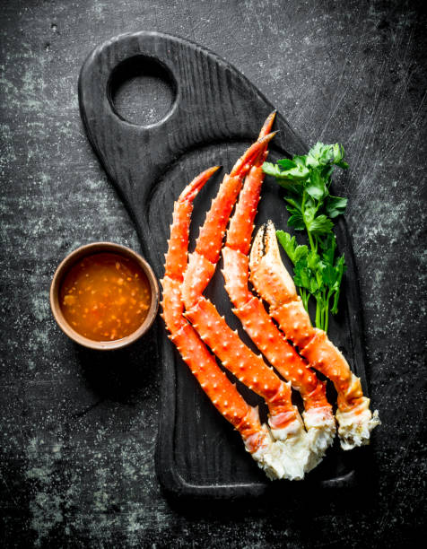 istock Crab on a cutting Board with greens and sauce in a bowl. 1156092210