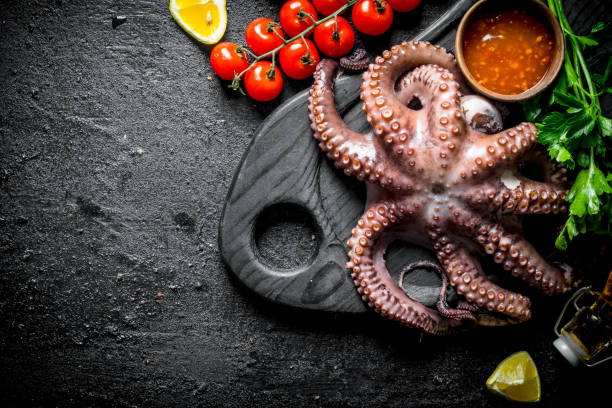 istock Fresh octopus on a cutting Board with sauce and tomatoes. 1156092297