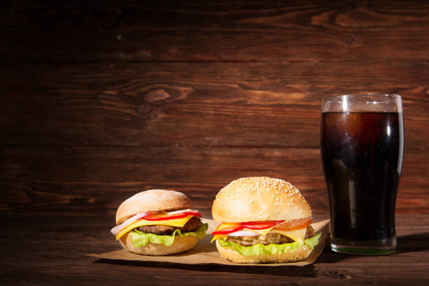 istock Two BBQ hamburgers with cola on wooden background. 1156093671
