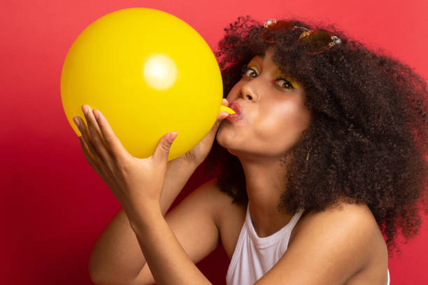 istock model with a lush hairstyle inflates a balloon 1156094923