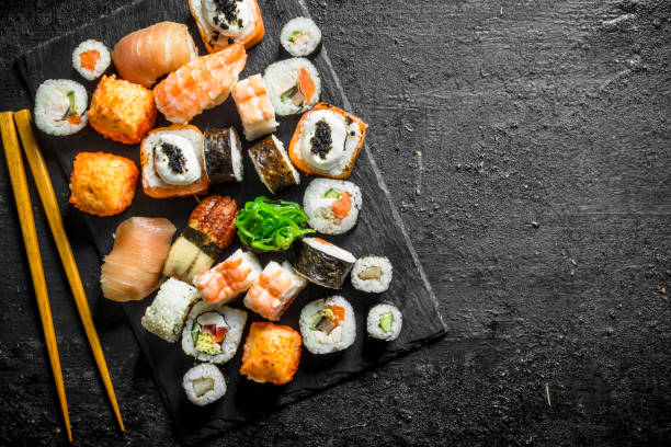 istock Delicious rolls, sushi and maki on a stone Board with chopsticks. 1156095775
