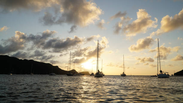 Sunset over Union Island with Sail boat yachts in the Tobago Cays near Saint Vincent and the Grenadines, Caribbean. Sunset over Union Island with Sail boat yachts in the Tobago Cays near Saint Vincent and the Grenadines, Caribbean. tobago cays stock pictures, royalty-free photos & images