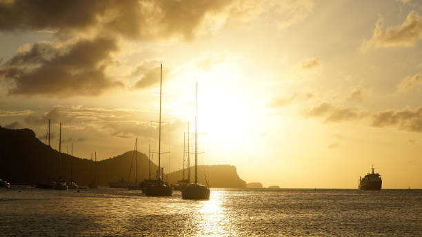 Sunset over Union Island with Sail boat yachts in the Tobago Cays near Saint Vincent and the Grenadines, Caribbean. Sunset over Union Island with Sail boat yachts in the Tobago Cays near Saint Vincent and the Grenadines, Caribbean. tobago cays stock pictures, royalty-free photos & images