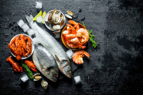 istock Raw fish and seafood on a stone Board with ice cubes and lime slices. 1156097896