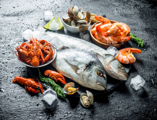 istock Seafood. Fresh fish with shrimp, crayfish and oysters on a stone Board. 1156097918