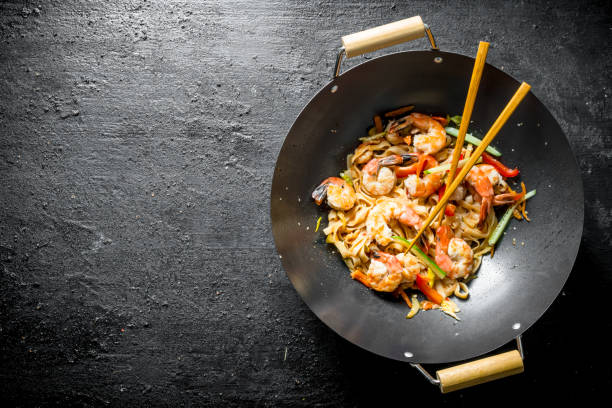 istock Chinese Udon noodles in a wok pan with chopsticks. 1156098939