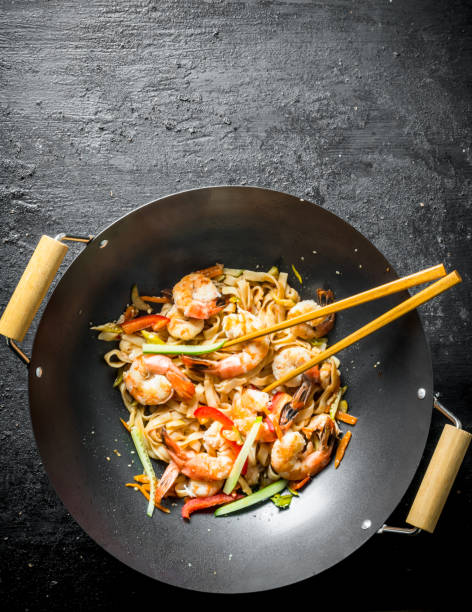 Fragrant Asian Udon noodles in a wok pan.