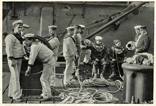 Royal Navy divers putting on diving suit, 19th Century