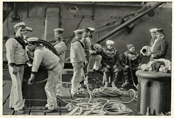 Royal Navy divers putting on diving suit, 19th Century Vintage photograph of Royal Navy divers putting on diving suit, 19th Century vintage sailor stock pictures, royalty-free photos & images