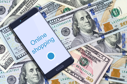 Concept Online Shopping. Smartphone on the background of dollar bills. Business. Finance. Background.