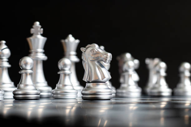 istock Silver knight chess piece stand in front of team on black background (Concept for leadership, management) 1156103063