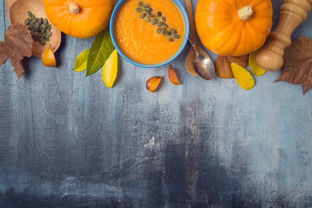 istock Pumpkin soup on rustic background. Autumn concept with pumpkin and fall leaves. Top view from above 1156103649