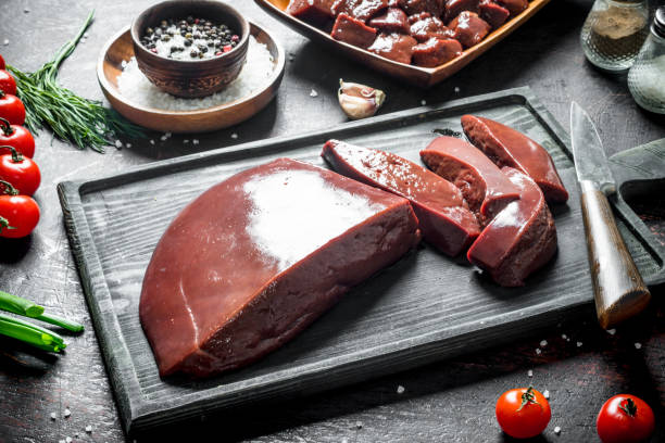 istock Sliced raw liver with tomatoes, herbs and spices. 1156105145