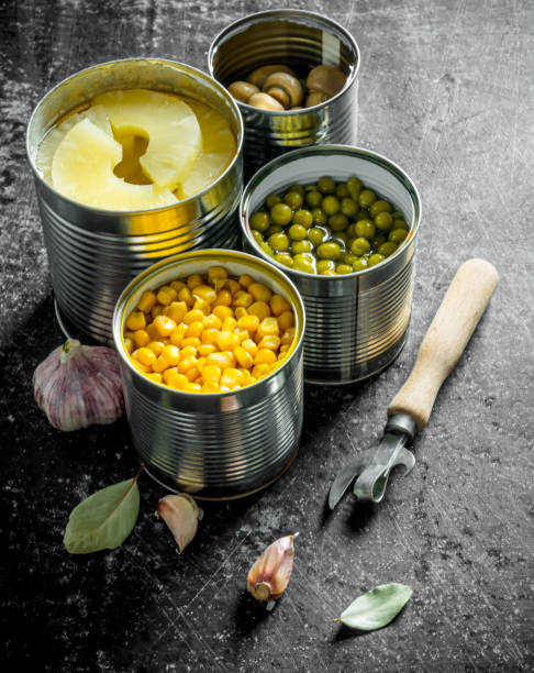 istock Canned pineapples, green peas, corn and mushrooms in open cans. 1156106914